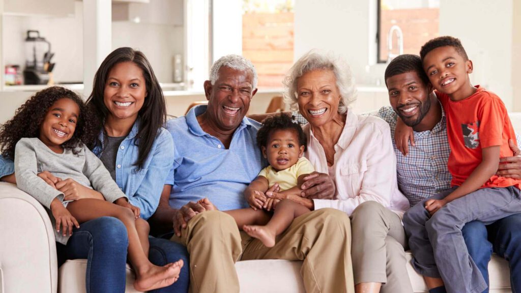 Happy family with grandparents in middle of couch
